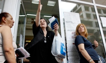 Una mujer saliendo de la  oficina del fondo estatal de salud en Atenas.  Los  pacientes dicen que han estado  yendo de farmacia en farmacia en busca de medicamentos recetados. F. John Kolesidis / Reuters